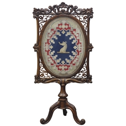  Victorian rosewood fire screen, frame carved with scrolls, shells and foliage, fret work corner brackets, oval bead and needlework panel depicting dog with feather, carved baluster columns with three splayed supports, H137cm  