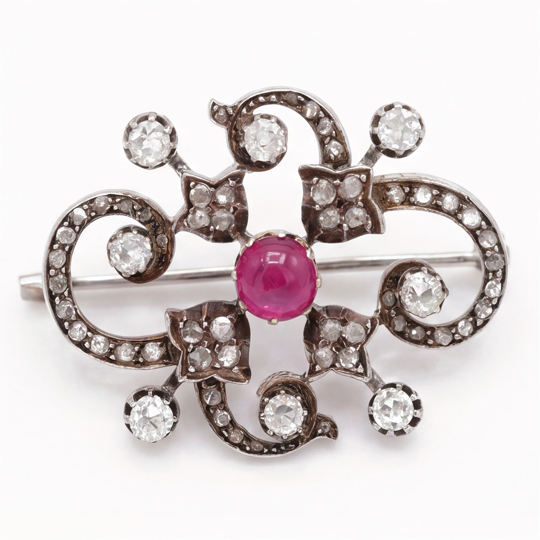 19th century French 18ct white gold ruby and diamond brooch by Eugène Fontenay, centrally set with a single cabochon cut ruby of approx 1.85 carat, the foliate scroll border set with eight old cut diamonds of approx 1.45 carat and rose cut diamonds, stamped with makers mark EF, eagles head and numbered 23960