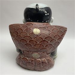 Japanese Fukusuke good fortune figure, modelled as a kneeling male figure holding a fan, dressed in traditional Samurai robes, H15.5cm