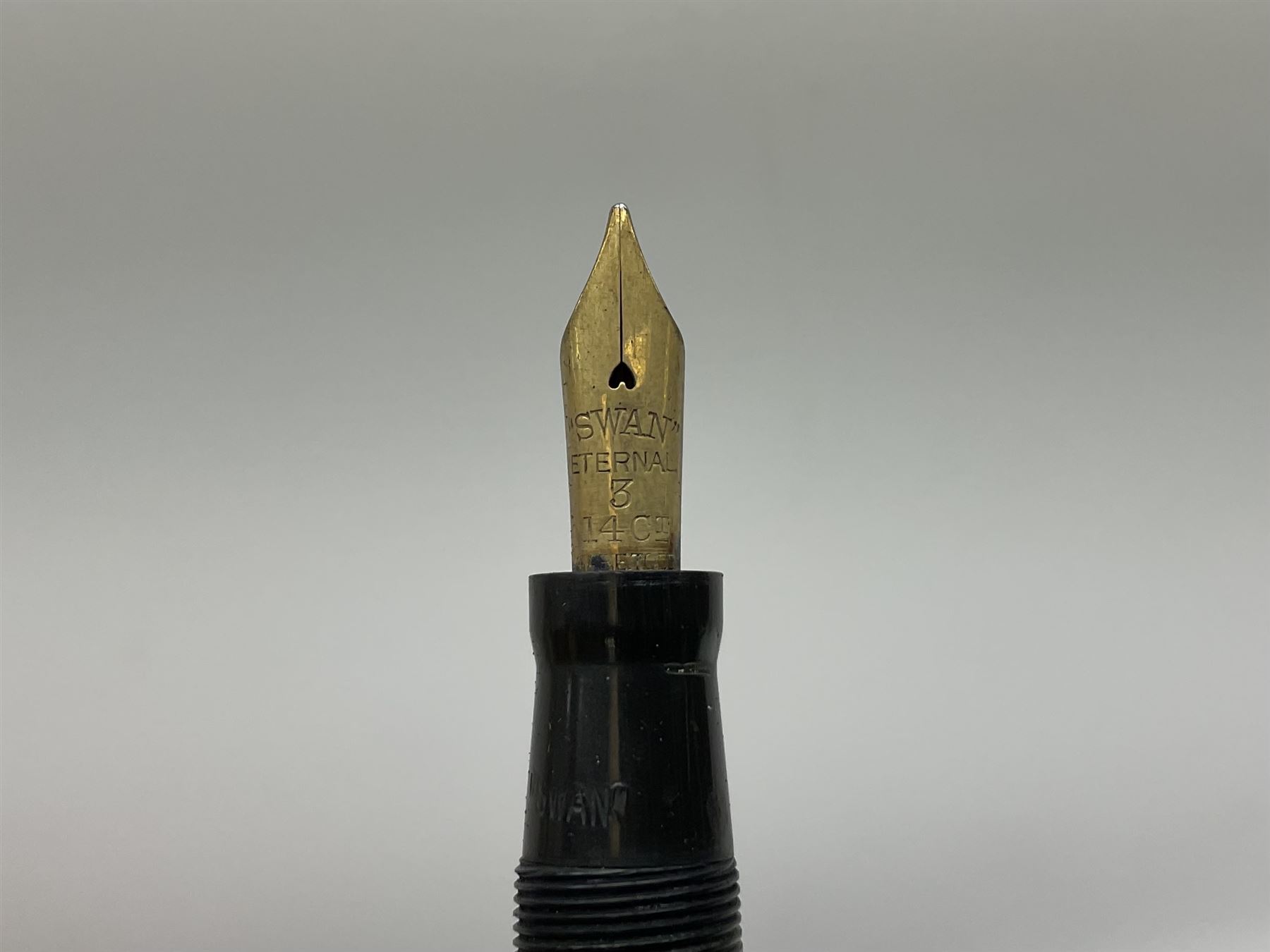 Vintage Swan Mabie Todd lever fill fountain pen in coral red, the nib a/f marked 14K, together with two further vintage Swan Mabie Todd fountain pens, the first example with lever fill, the other leverless, each with black body, one with nib marked 14ct, (3) 