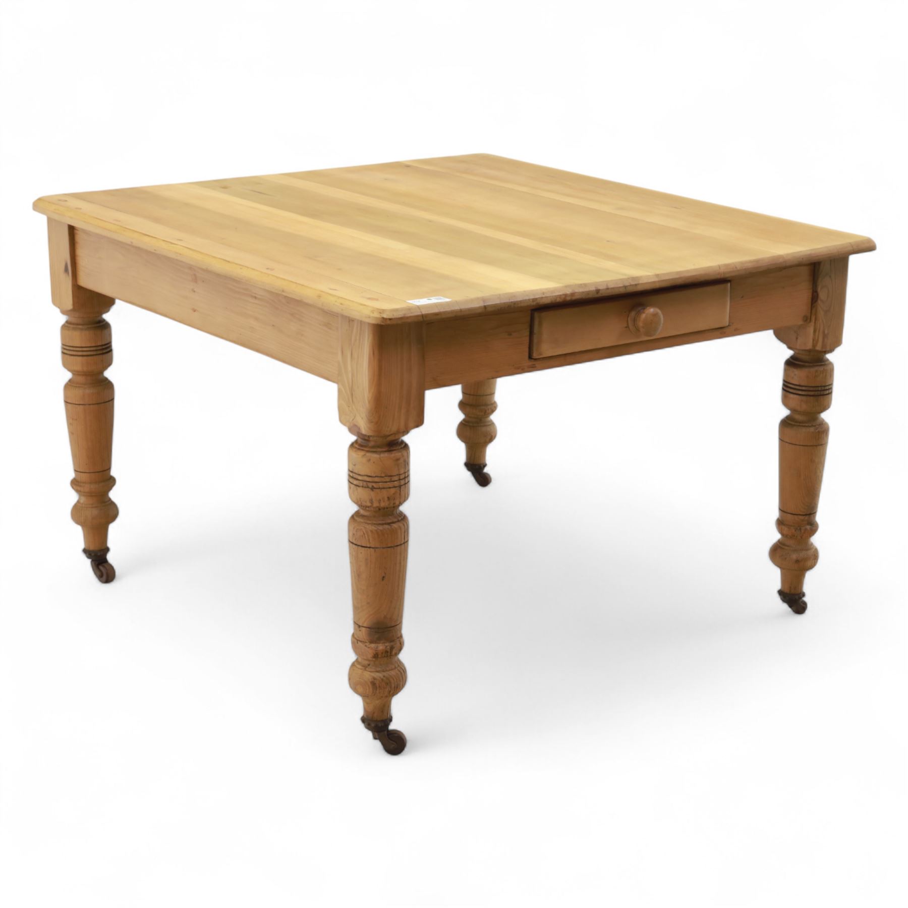 Contemporary pine kitchen table, rectangular top with moulded edge, fitted with single drawer, raised on turned supports with ceramic castors
