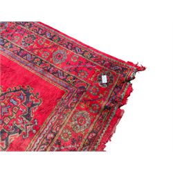 Early 20th century Western Anatolia Turkish Oushak crimson ground carpet, the field decorated with rows of Herati and Palmette medallions, the main border decorated with stylised flower head motifs within guard stripes