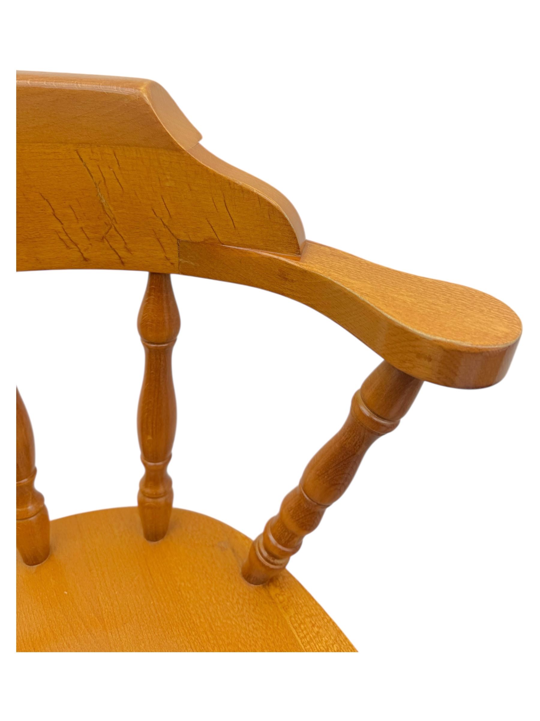 Pair of late 20th century beech bar stools, with curved top rail and turned spindle back, shaped seat over four turned legs united by multiple stretchers