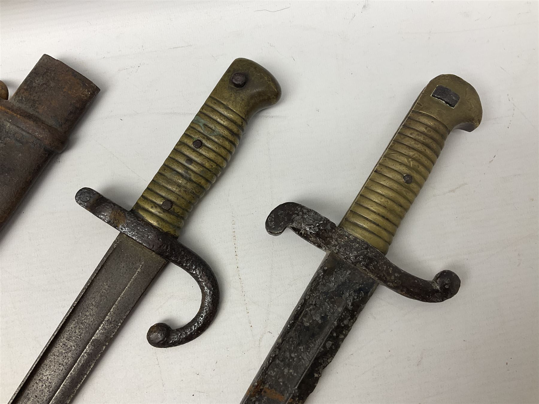 French Model 1874 Epee bayonet marked Oulle 1876 in associated scabbard; Model 1866 sabre bayonet in cut-down sword scabbard; and Model 1842/59 sabre bayonet in relic condition (3)