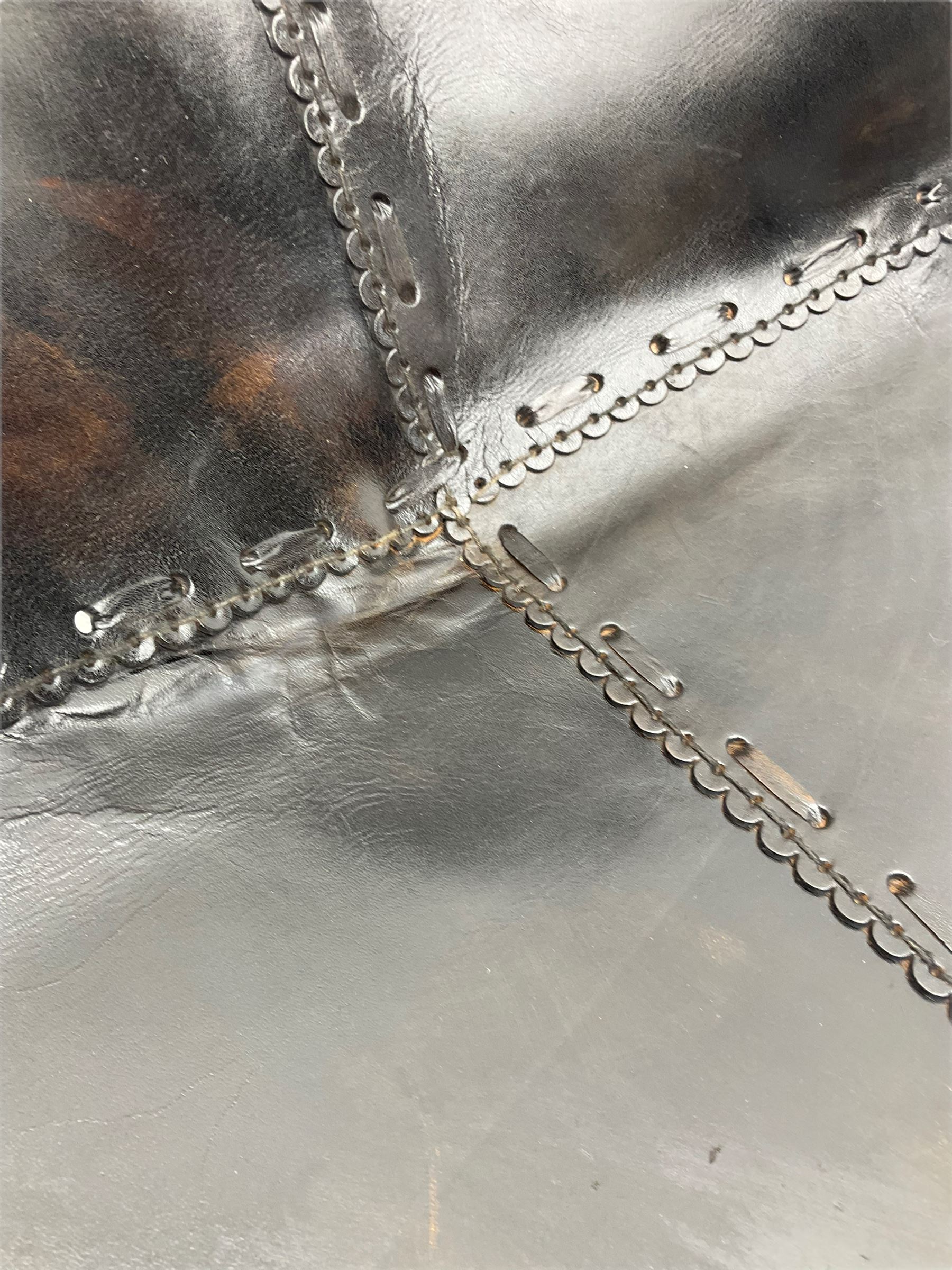 Metal framed butterfly chair upholstered in slung dark tan stitched leather 
