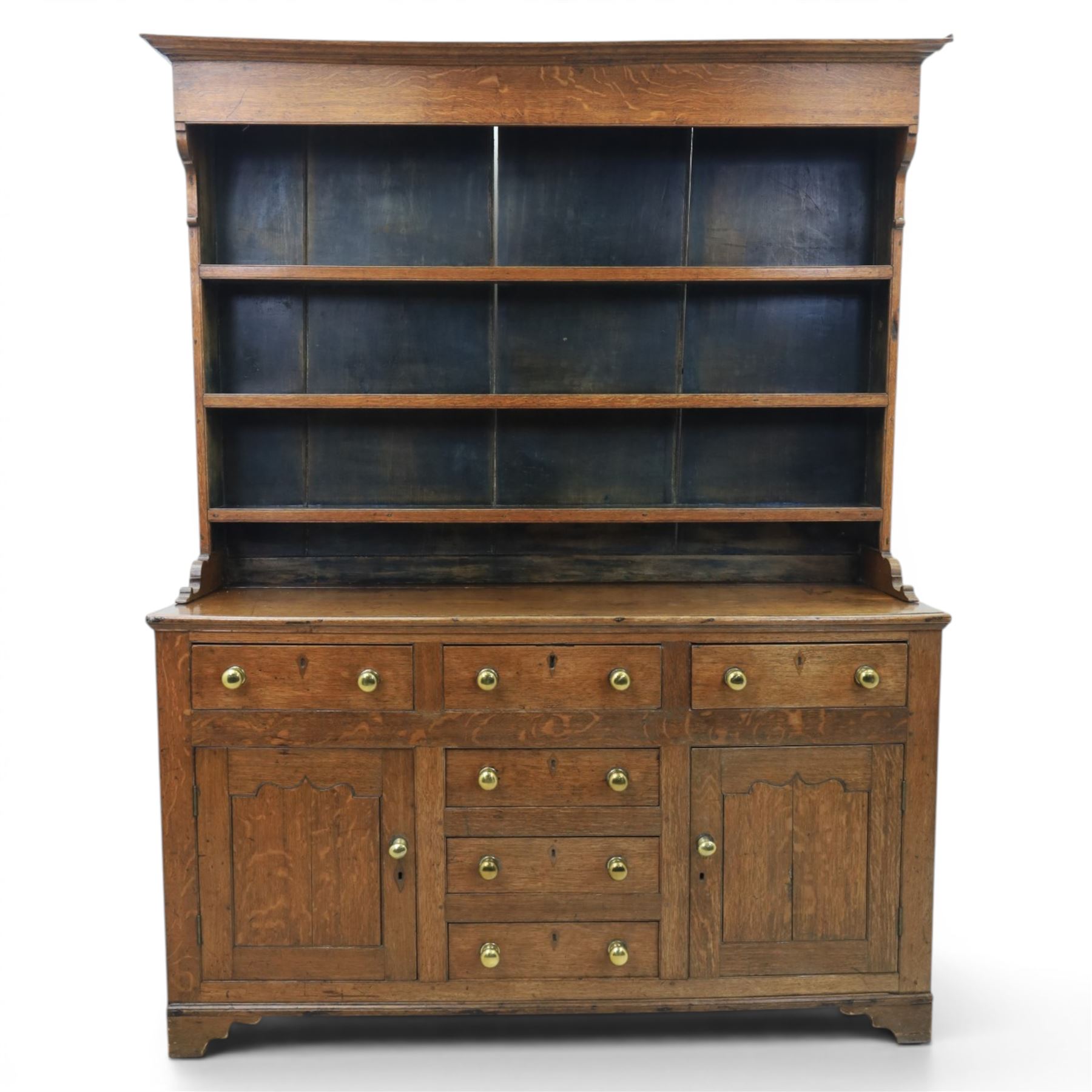 18th century Georgian oak dresser and rack, three back-boarded plate shelves, above six drawers and two cupboards, raised on bracket feet