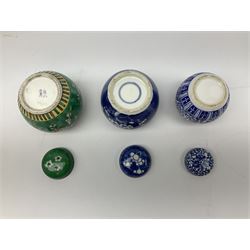 Six Chinese ginger jars, predominantly of blue and white design decorated with blossoming branches, all with lids, housed on various hardwood carved stands, some with character marks beneath