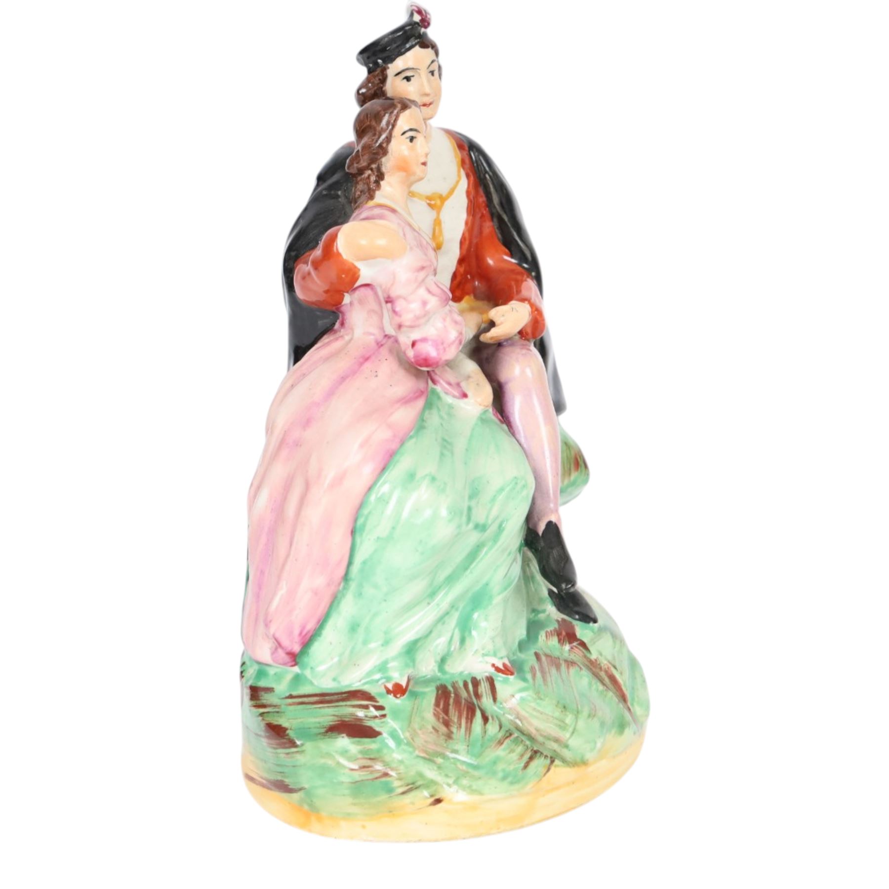 Rare Staffordshire pottery figure group, circa 1852, modelled as Romeo and Juliet, both seated upon a naturalistic base with their arms around one another, Romeo wearing cloak and plumed hat, Juliet in long dress, H20cm
