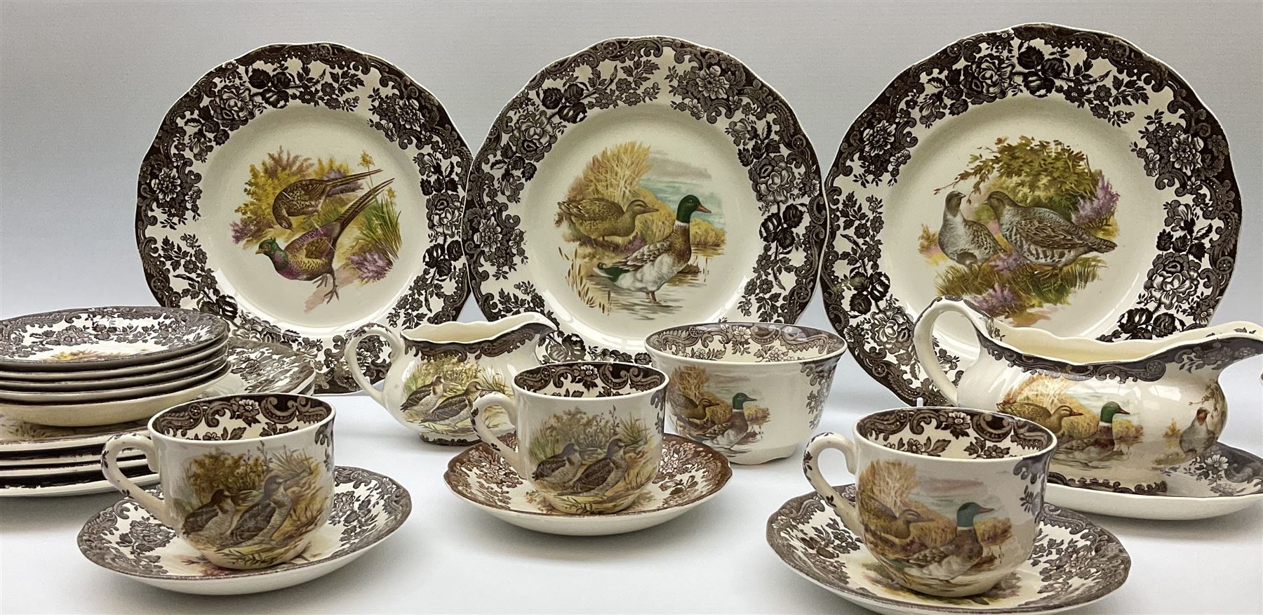 Royal Worcester Palissy Game Series pattern dinner wares, comprising seven dinner plates, six side plates, twelve bowls, sauce boat and stand, six tea cups, eight saucers, further larger saucer, milk jug, and open sucrier. 