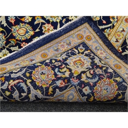  Persian Kashan rug carpet, blue ground field with scrolling foliate and stylised flower heads, repeating guarded border, signed on border, 340cm x 245cm  