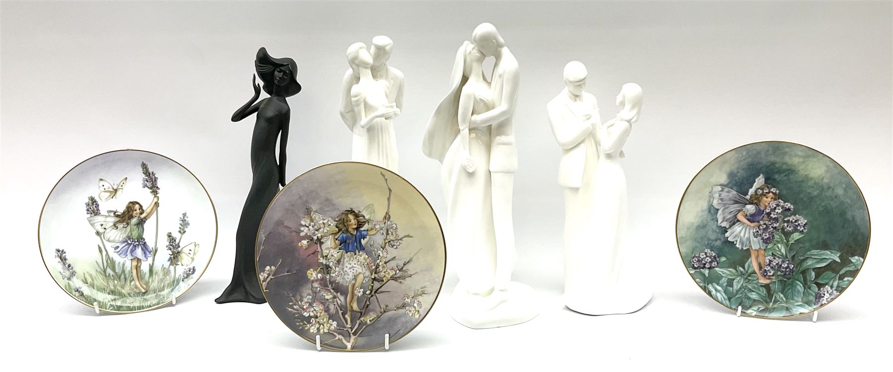 Four Royal Doulton Images figures comprising 'Happy Anniversary', 'Wedding Day', 'Congratulations' and 'Carefree', together with a set of three Heinrich collectors plates depicting Fairies.