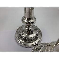 Four George III silver candlesticks, each upon knopped stem and weighted circular stepped foot, the foot and removable sconce repousse decorated with a band of flower heads, hallmarked to sconce and foot Thomas & John Settle, Sheffield 1820, H17.5cm