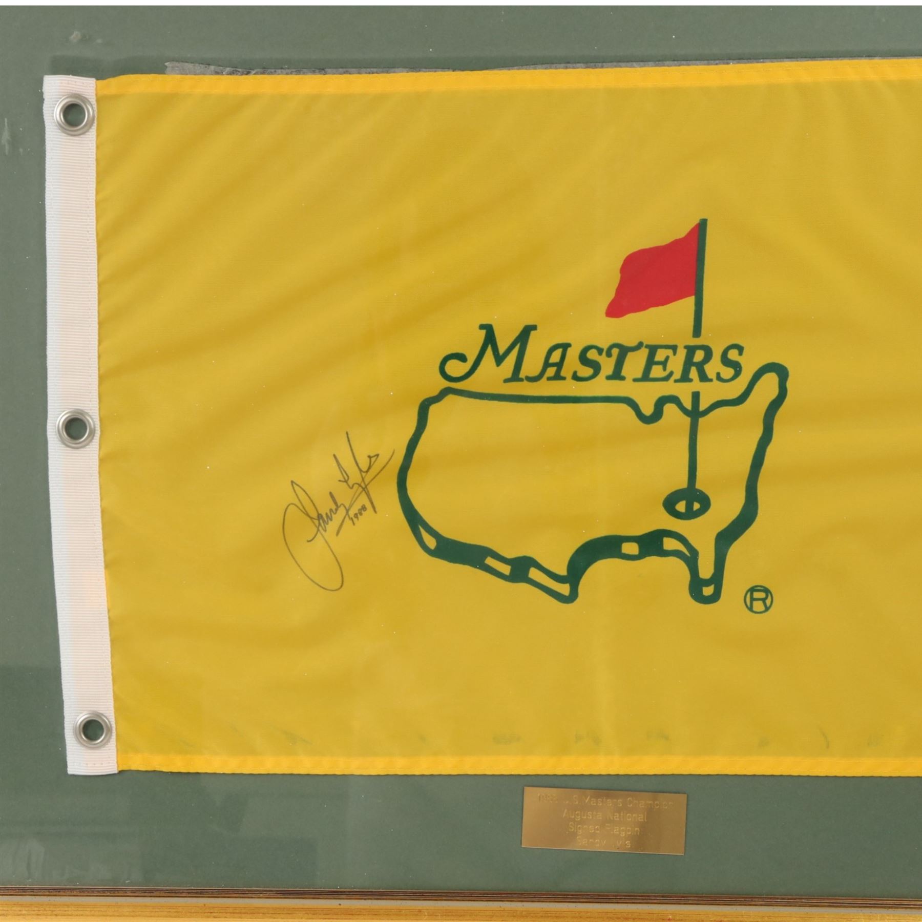 Signed golf memorabilia, to include 1988 US Masters Champion Augusta National flag, signed by Sandy Lyle, a golfing glove signed by Nick Faldo, two signed 2002 Ryder Cup prints, 1979 Masters scorecard signed by Fuzzy Zoeller displayed with a 1980 Masters scorecard signed by Seve Ballesteros, all framed, largest frame H60cm