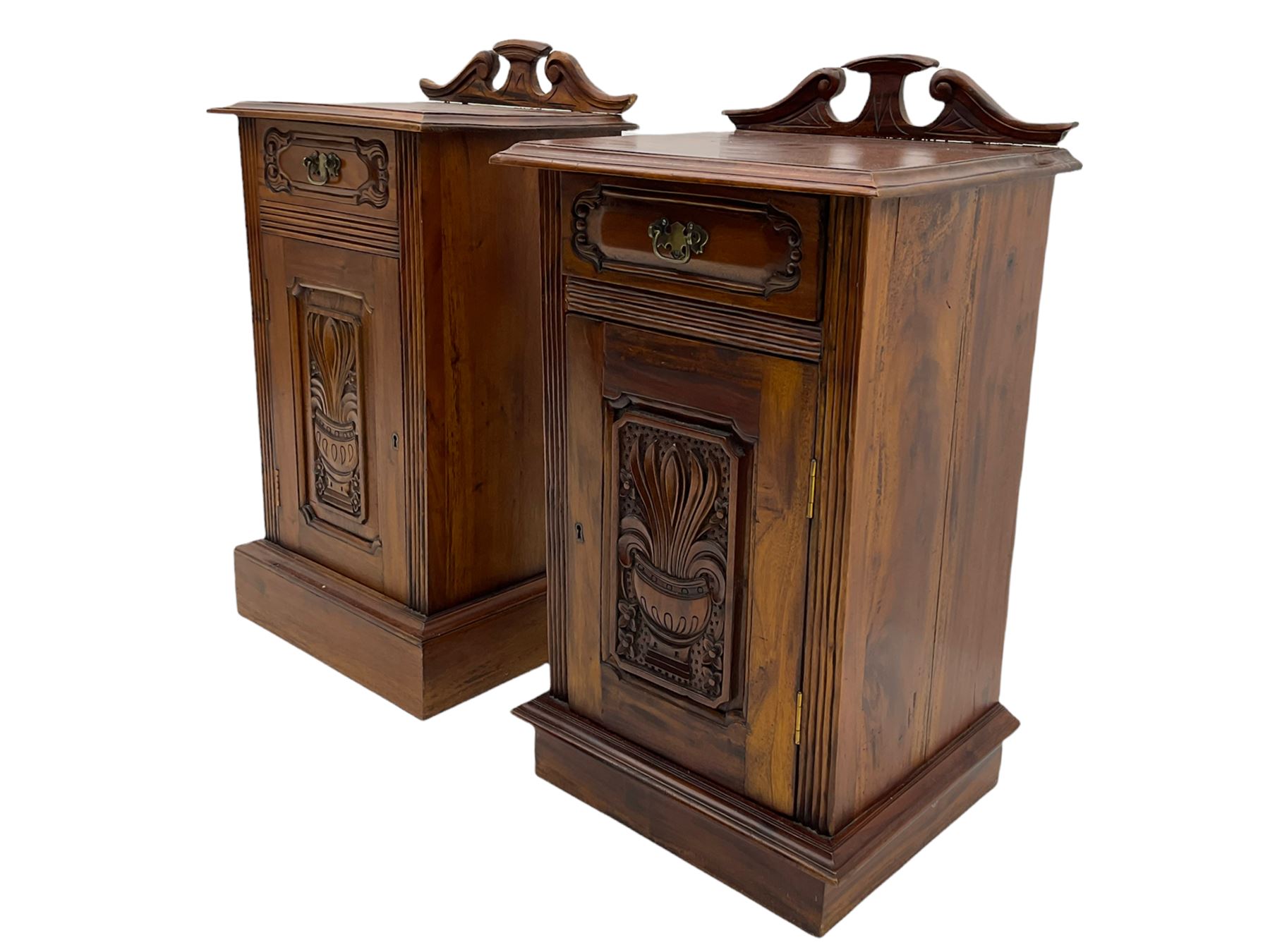 Pair Victorian style hardwood bedside cabinets, fitted with single drawer and cupboard, the doors carved with floral urns, on plinth bases