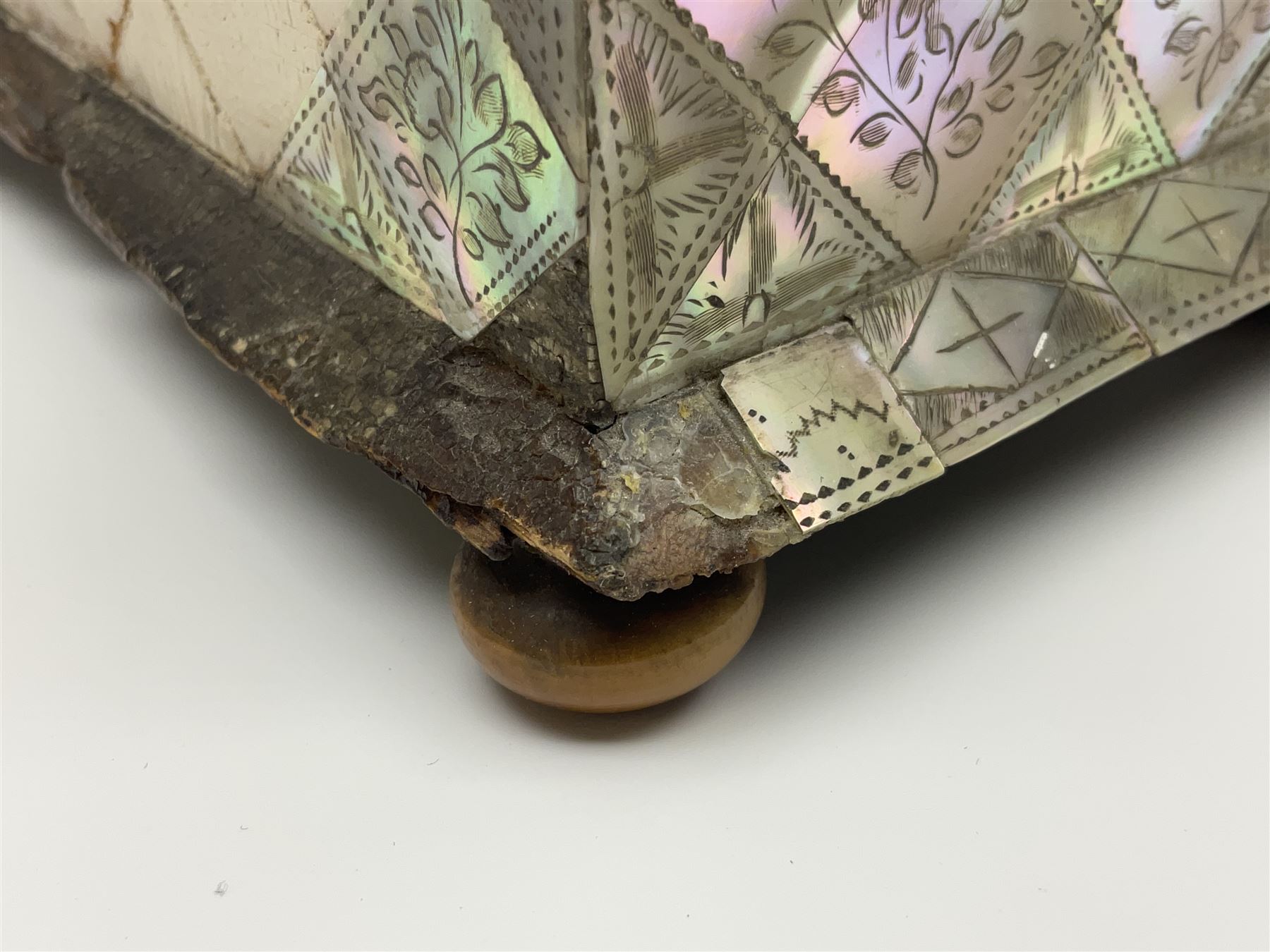 Victorian mother of pearl tea caddy, of rectangular bow-fronted form, the body with floral, bird and geometric engraved mother of pearl panels, white metal shield plaque to the cover inscribed with the initials G.J.A and similar escutcheon, the two division interior with ivory edging and two panelled mother of pearl lids, on four vegetable ivory bun feet L20cm, together with a similar style mother of pearl card case (2) This item has been registered for sale under Section 10 of the APHA Ivory Act