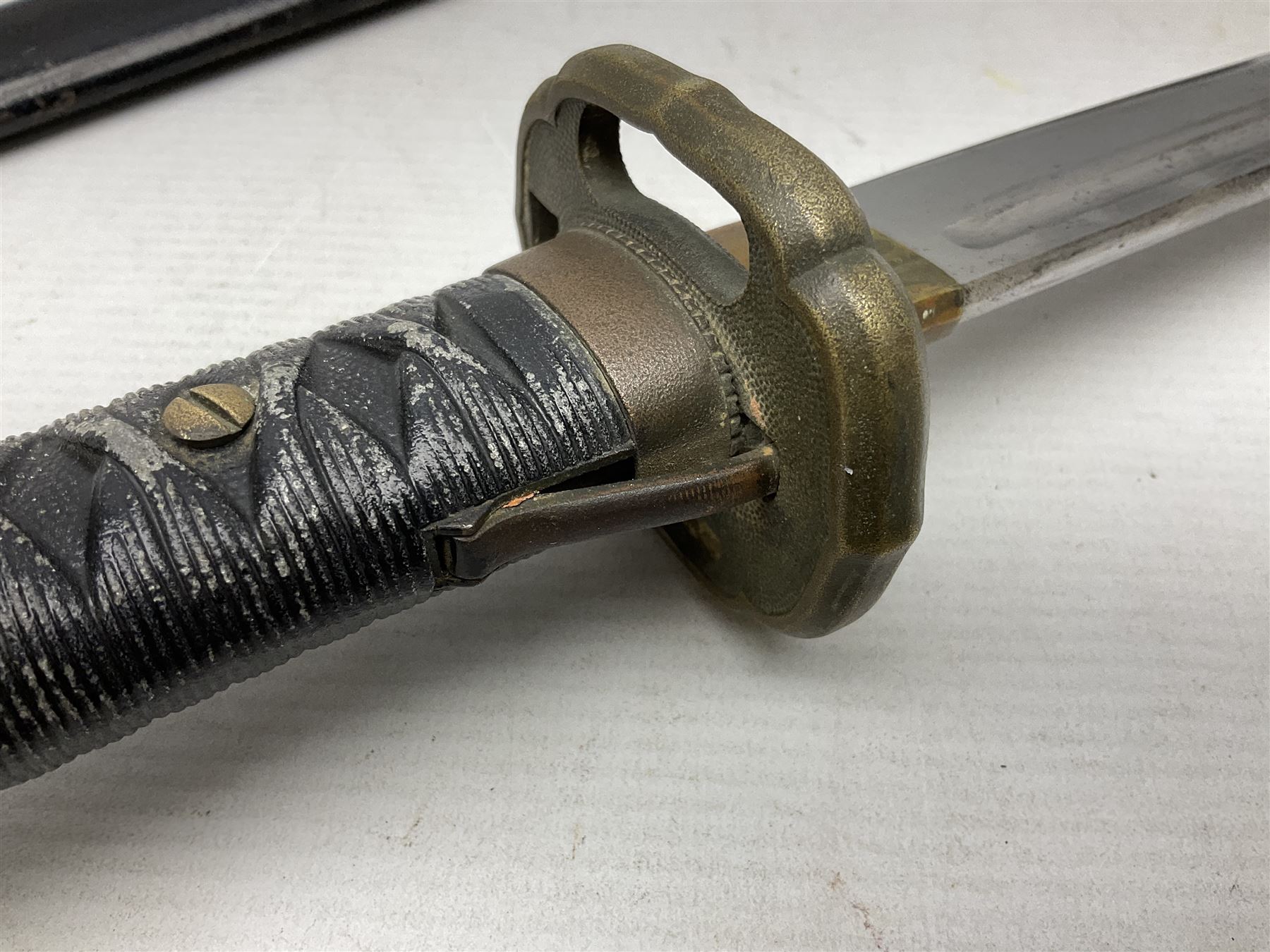 WW2 Japanese Army NCOs sword - katana, the 69.5cm slightly curving fullered blade numbered 14656; arsenal markings stamped near the habaki on the handle; brass tsuba and black painted metal hilt cast to simulate cord bound fish skin; in black painted steel scabbard with single suspension ring L96cm overall