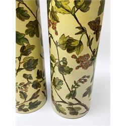 A pair of 19th century Doulton Lambeth vases, of cylindrical form hand painted with butterflies amongst blossoming branches, with impressed marks beneath and dated 1875, H26.5cm. 