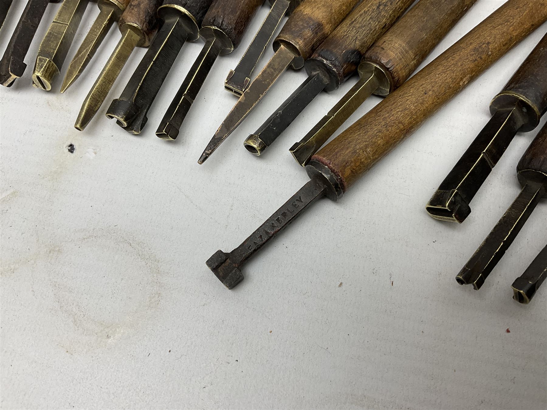 Thirty-one bookbinder's brass number and letter stamps, predominantly with beech handles, together with a bookbinder' decorative fillet roll, with brass triple line wheel stamped E. Menuel London, with wood handle, and two ink blotters