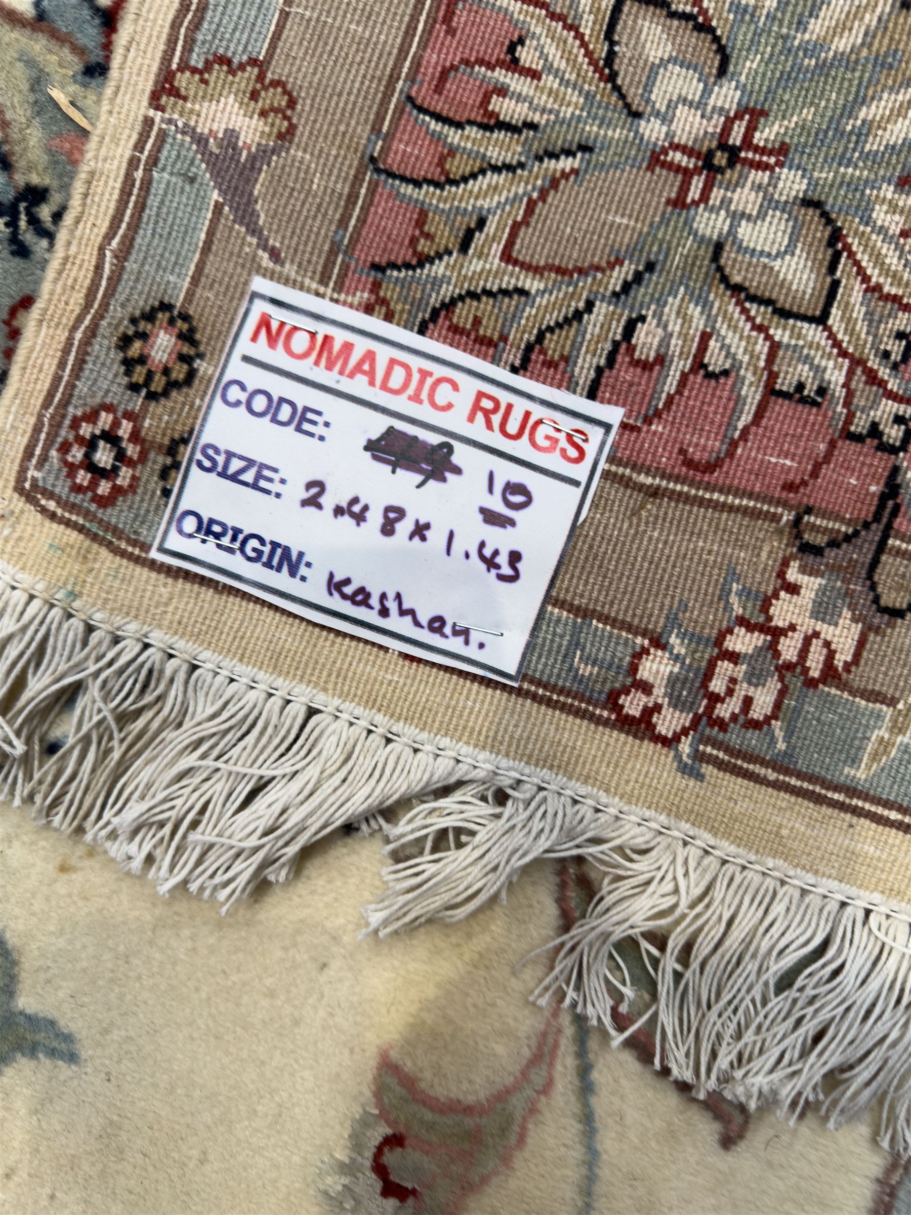 North East Persian Kashmar hand-knotted rug, ivory field with an all-over design of linked floral medallions and scrolling vines with a central circular medallion enclosed by multiple borders and a main broad madder field with palmettes and arabesques, 248cm x 145cm