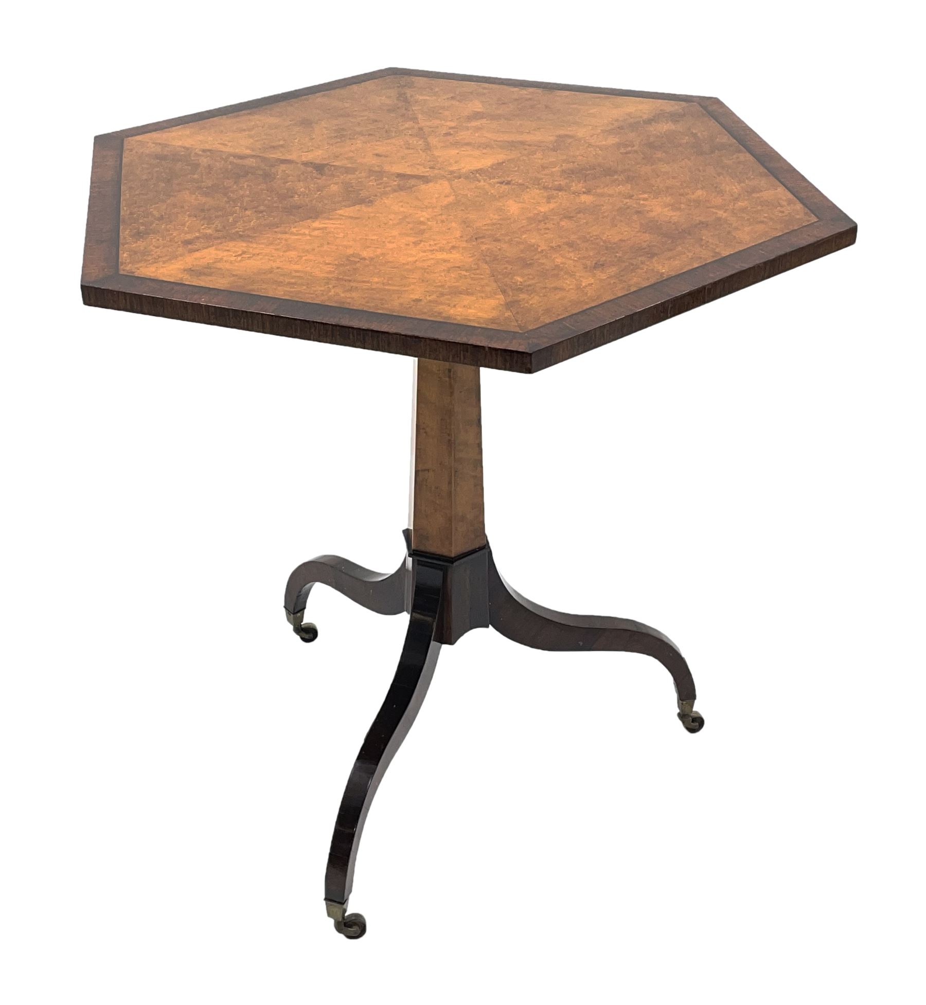 Regency style birdseye maple and rosewood tripod table, hexagonal tilt top with segmented veneer and banding, tapered hexagonal column on three splayed serpentine supports, brass cups and castors 