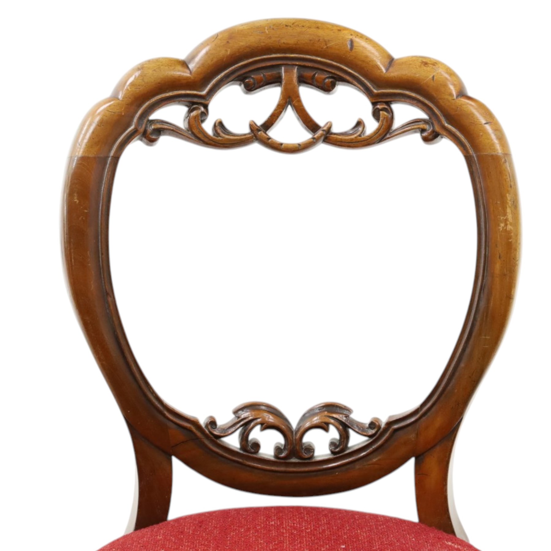Set of five Victorian mahogany dining chairs, the scalloped balloon back with pierced scrolling acanthus leaf decoration, sprung seats upholstered in crimson fabric, on cabriole supports