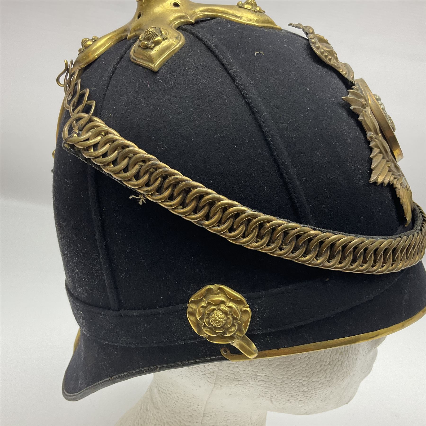 Late Victorian North Staffordshire Regiment Officer's Home Service Blue Cloth Helmet, having incorrect other ranks gilt metal Queen's crown helmet plate to the front with later leather backing, removable spike to the top on a shaped cruciform base with rosette fittings, rosette side bosses, brass trim to the front peak, and leather and velvet backed chin scales, with leather sweat band, the interior with makers stamp for Hawkes & Co 14 Piccadilly London