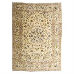 Central Persian Kashan hand-knotted carpet, ivory ground, with a central shaped floral med...
