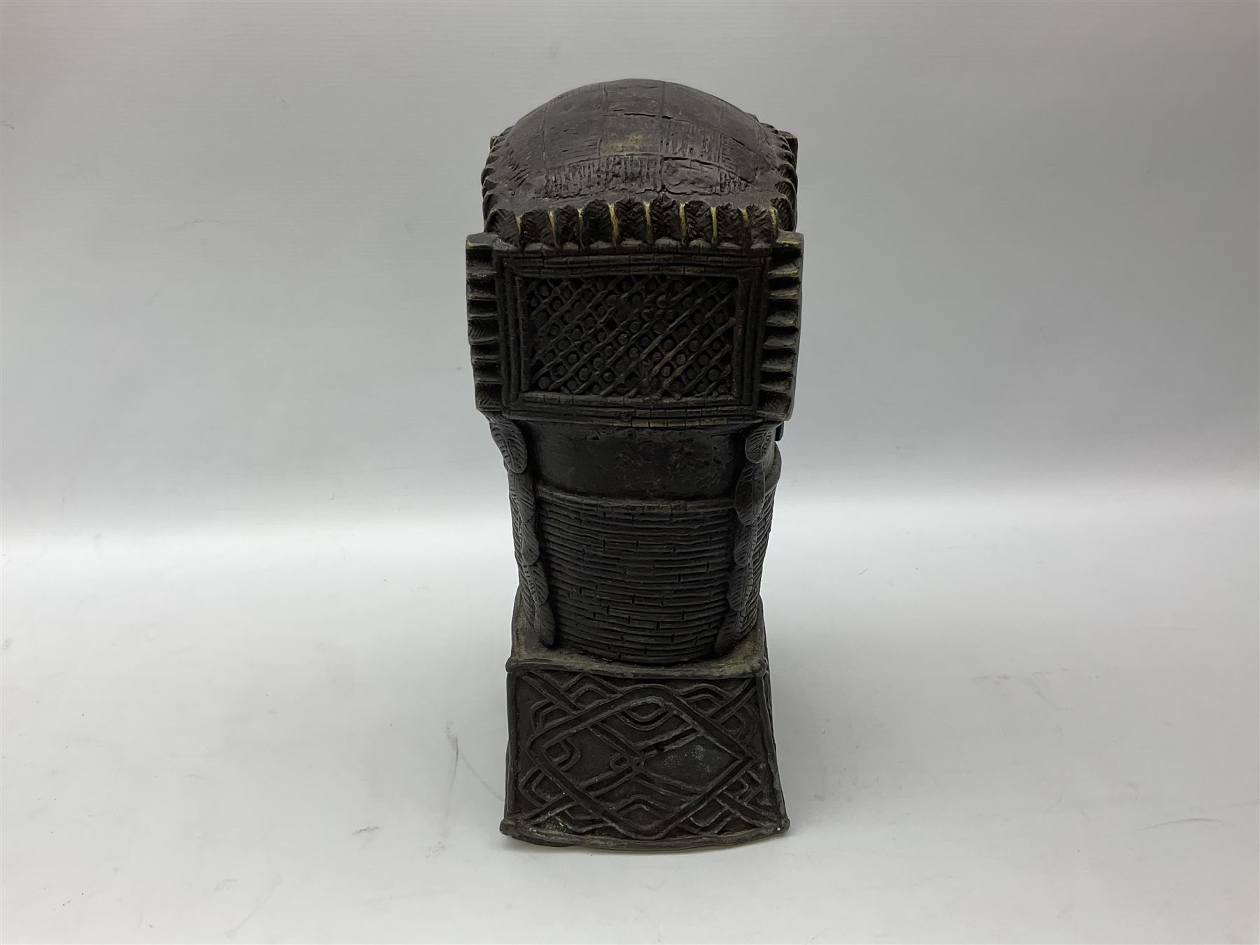 20th century Benin bronze head of an Oba, donning headdress and neck rings with wide open eyes, raised upon a tapering square base, the sides with relief cast knot decoration, H39cm