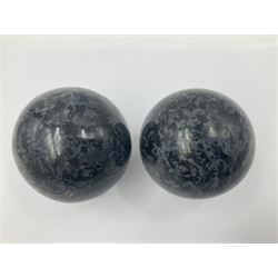 Pair of indigo gabbro spheres, upon carved wooden bases, D8cm