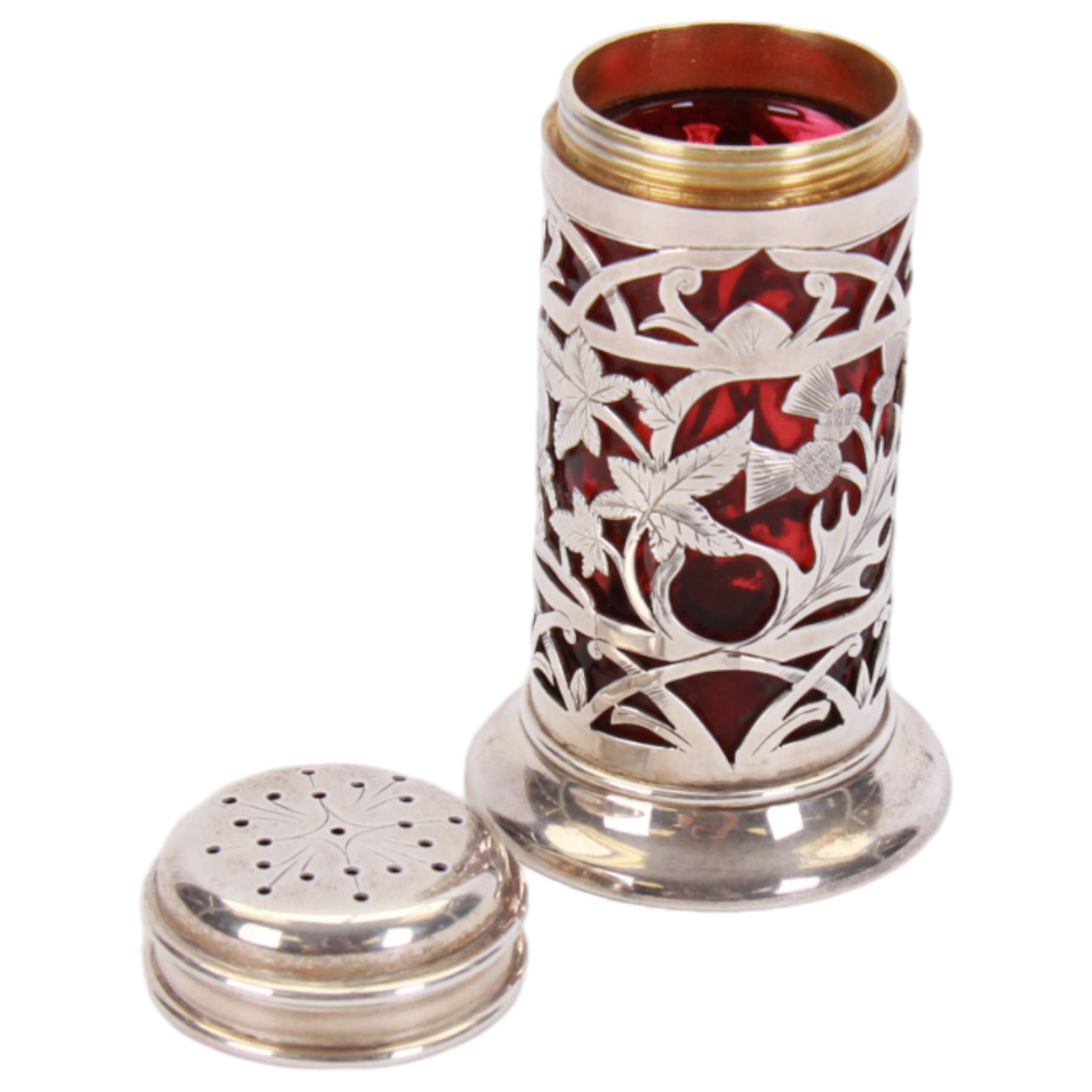 Late Victorian silver pepper, of cylindrical form with screw threaded pierced flat topped cover, the openwork body decorated with flowers of the Union, roses, thistles and shamrocks, revealing a ruby glass liner, upon a spreading circular foot, hallmarked Harrison Brothers & Howson, London 1900, H8cm