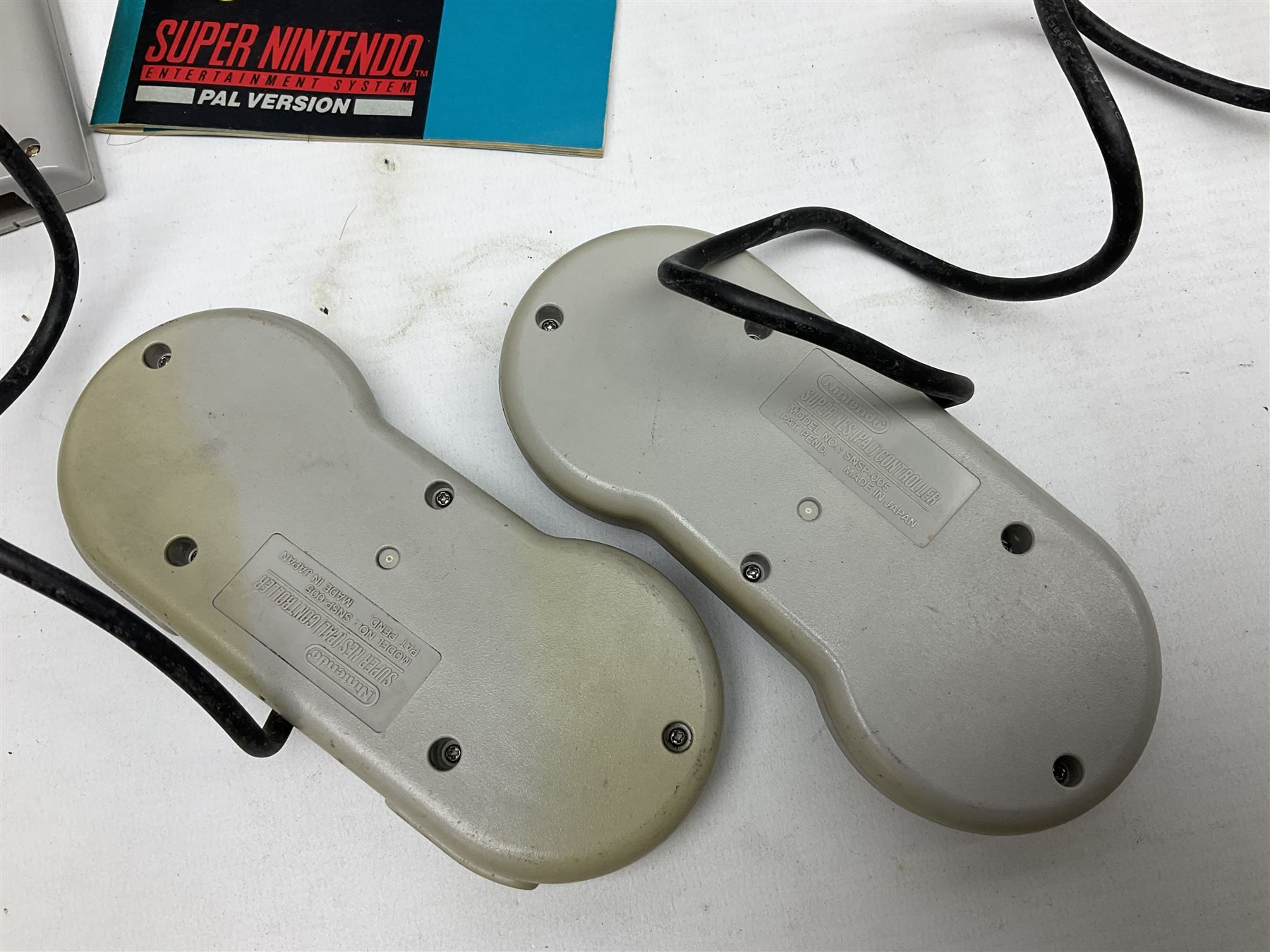 Two Super Nintendo Entertainment System (PAL) controllers, accessories and games. Super NES Game Commander with original box and instruction booklet, Super NES Nintendo Scope (1992) transmitter gun, receiver, Super NES Nintendo Scope 6 game with original instruction booklets. Further games to include ‘The Legend of Zelda a Link to the Past’, ‘Super Mario World’, ‘Super Mario Kart’, ‘The Lawnmower Man’, and ‘Exhaust Heat’, all with original instruction booklets. ‘PowerMonger’ and Disney’s ‘Aladdin’ game cartridges only 