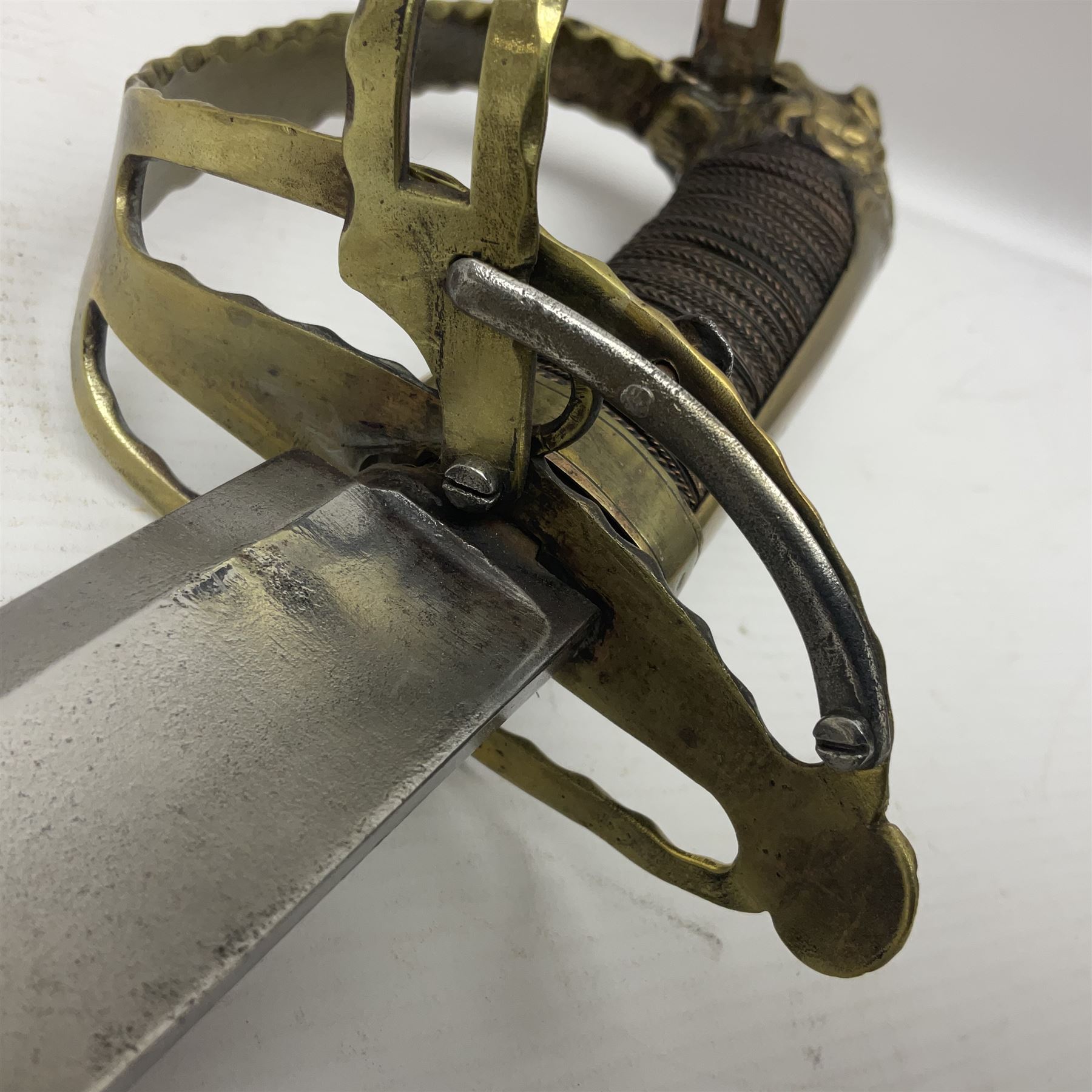 Late 18th century French 1st Empire Troupe a Pied Petit Montmorency Branch Tournante officer's sword, with 72.5cm slightly curving fullered blade, pierced brass hilt with lockable swivelling bar, fully wire-bound grip with lion head pommel, L88cm overall (no scabbard)