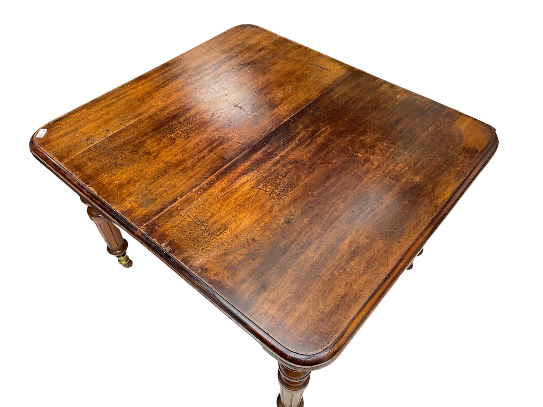 19th century mahogany extending dining table, moulded rectangular top with rounded corners, on turned and fluted supports with brass and ceramic castors