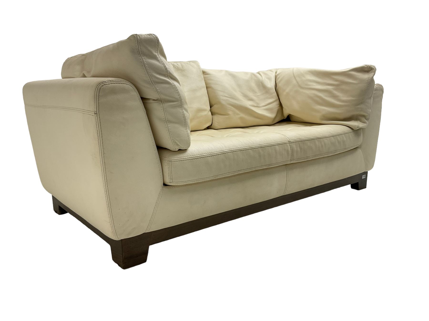 Roche-Bobois - two seat sofa, upholstered in ivory leather with buttoned seat cushions, raised on a stained beech base with bracket feet