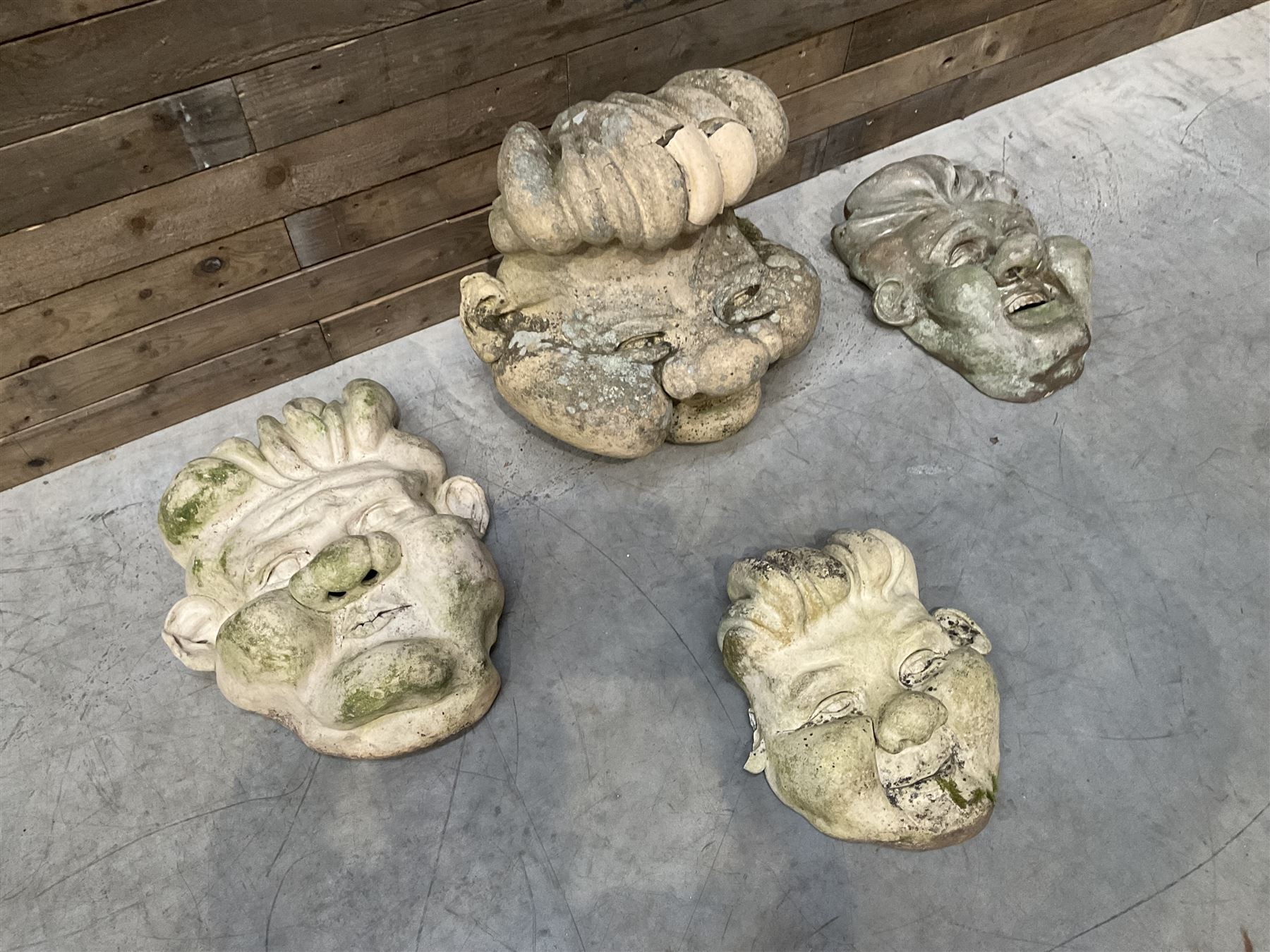 Four grotesque garden wall masks