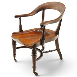 19th century carved mahogany Captain's desk chair, the bow-shaped cresting rail over curved back and turned arm supports, shaped saddle seat raised on turned supports united by crinoline stretcher, with brass cups and ceramic castors