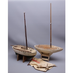  Two pond yachts - one with white and green painted wooden hull, weighted metal keel and simulated planked deck with hatches L46cm H72cm on wooden stand inset with enamelled Norwegian flag, the other with white painted wooden hull, weighted metal keel and plain wooden deck L46cm H77cm, on wooden stand (2)  