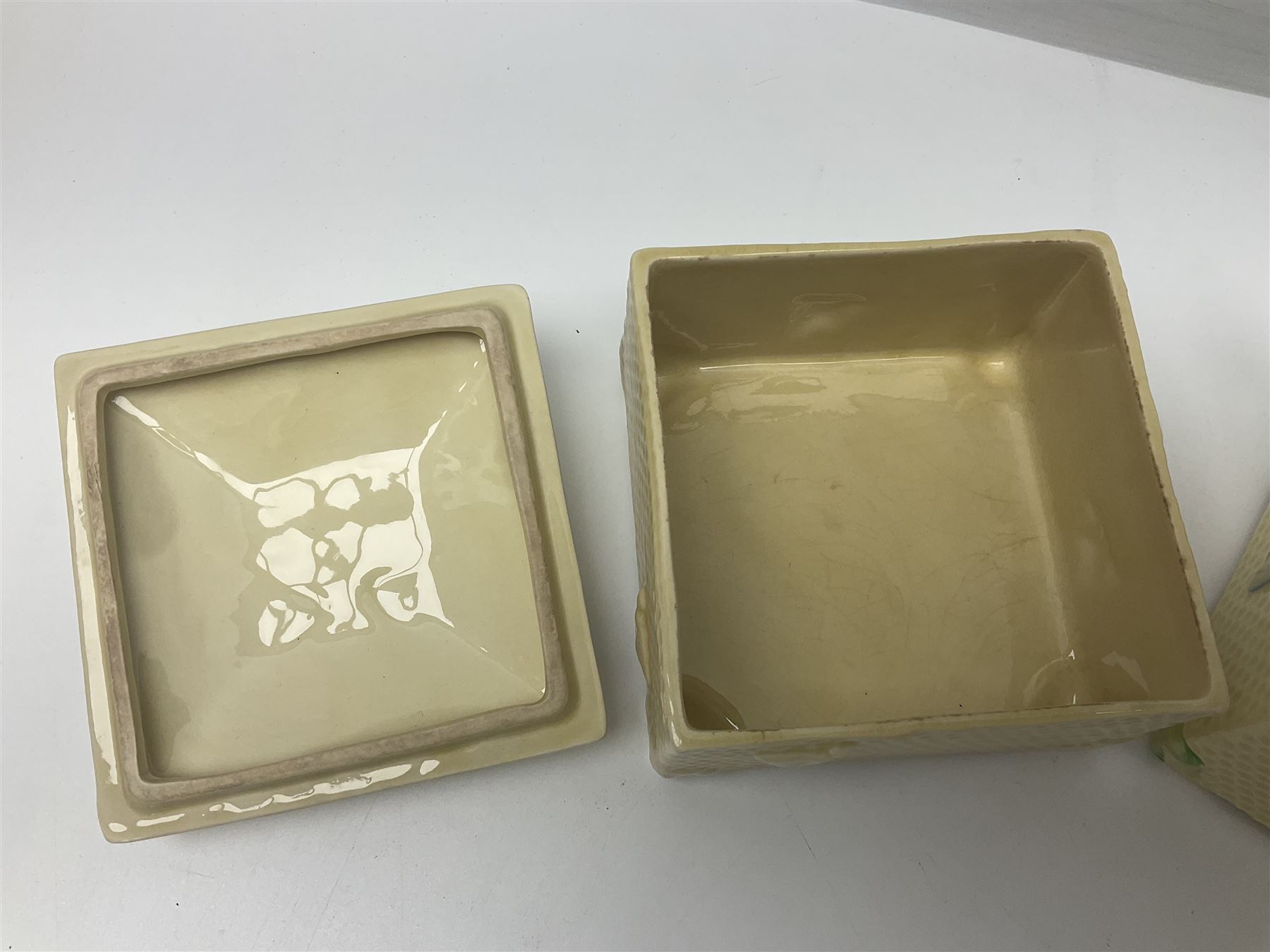 Four square honey boxes with lids,  each decorated with honeycomb pattern and finished with a bee finial