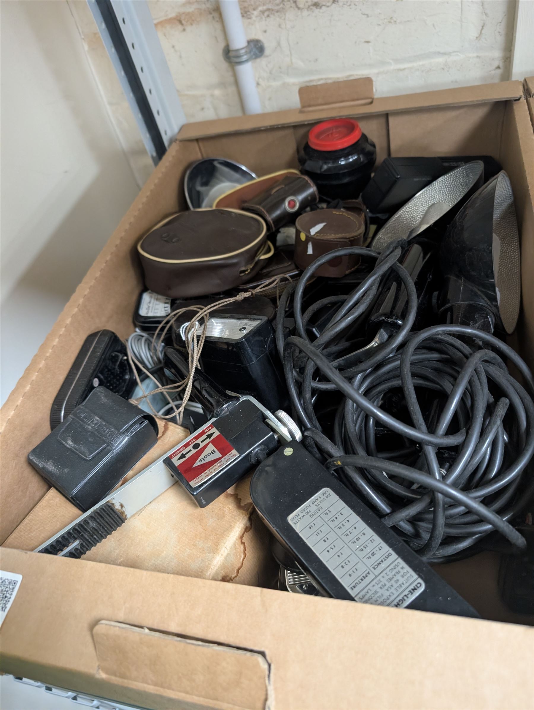 Collection of camera flashes and light meters, including Weston Master light meters, Braun Hobby flash, Hanimex XP1, in two boxes