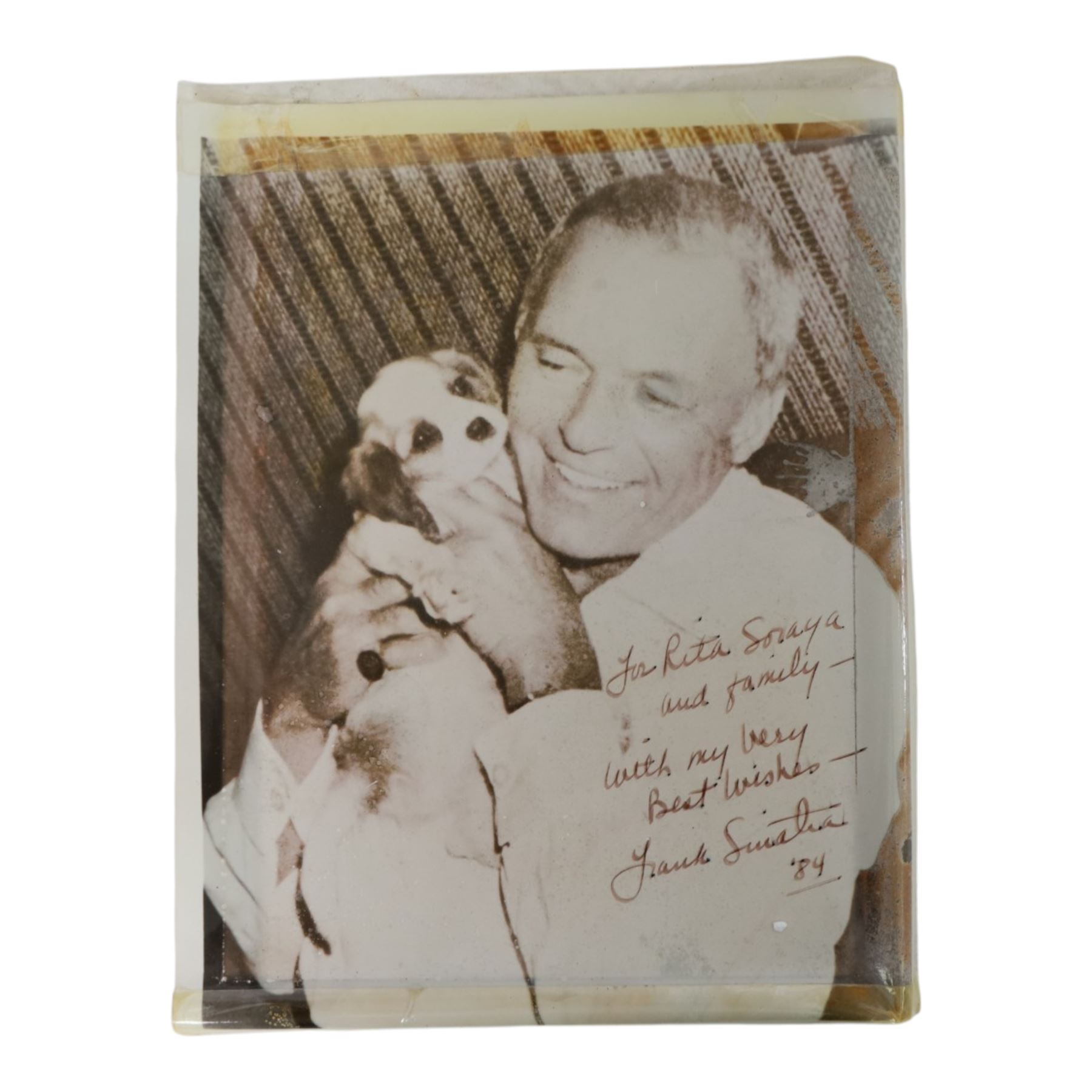 Frank Sinatra signed black and white photograph, the image depicting the singer holding a puppy, signed to the bottom right corner 'To Rita, Soraya and family, with my love and best wishes Frank Sinatra 84'

By venodr repute: signed 'To Rita, Soraya and family' - Rita was the vendor's mother. Sinatra signed the photograph after his 1984 performance at the Royal Albert Hall; his agent Harold Davison was married to the singer Marion Ryan who was a friend of Rita.