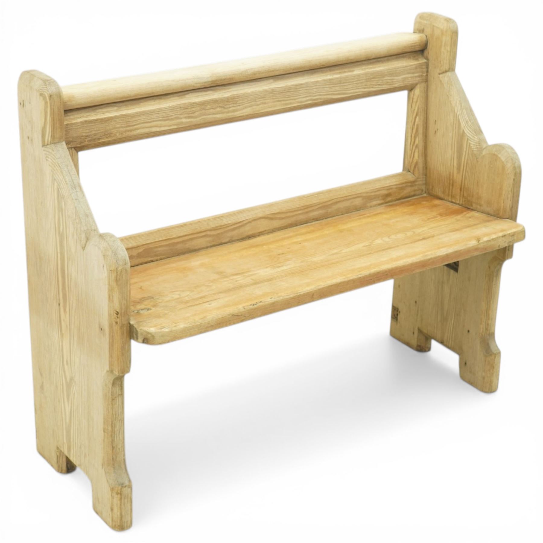 19th century pine pew of small proportions, open rectangular back with panelled frame, rounded top rail and plank seat, shaped slab ends with chamfered detail