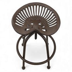 Industrial design pair of cast metal 'tractor seat' revolving bar stools, each with pierced tractor seat shaped top from the early 20th century, raised upon tubular steel supports with circular footrests (Height adjustable from 77cm - 93cm)