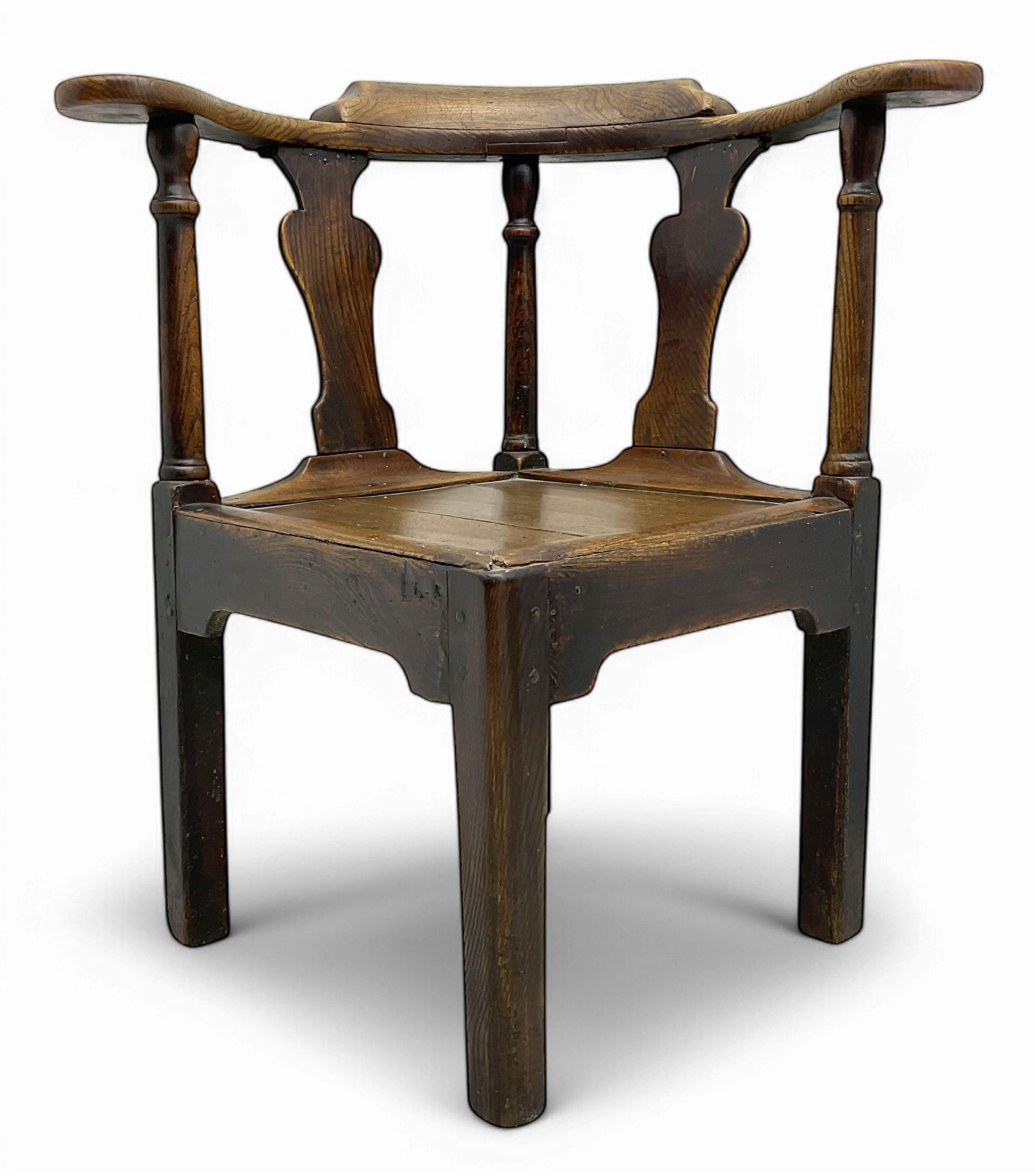 18th century oak corner elbow chair, the shaped cresting rail terminating to swept arm rests, supported by turned columns and vase-shaped splats, over square plank seat, raised on square-section supports