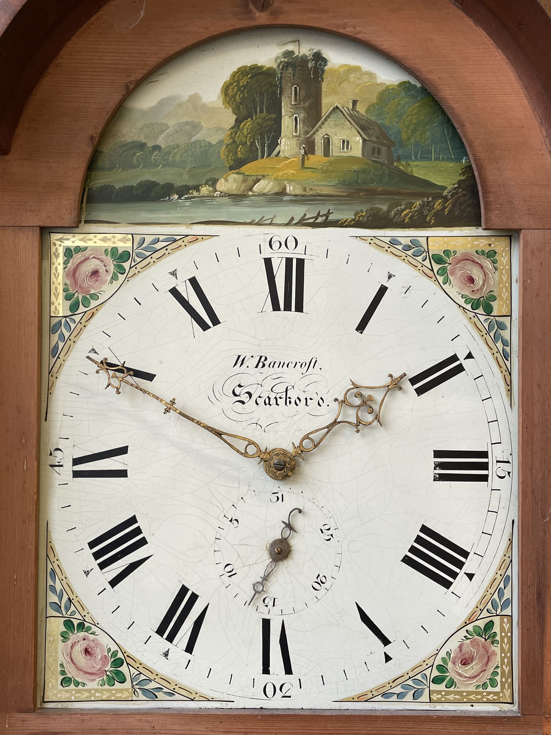 Thirty-hour oak cased longcase clock by  William Bancroft of Scarborough circa 1830, with a swan’s neck pediment, brass patera and three brass spire and ball finials, stepped break arch hood door flanked by plain pillars with brass capitals, trunk with a full length door and curved arch top, on a plain square plinth with bracket feet, painted break arch dial with roman numerals and quarter hour Arabic’s, date recorder (anti clockwise) and matching brass hands, arch painted with a rural scene depicting a ruined tower and cottage with depictions of flowers to the spandrels, dial pinned directly to a chain driven countwheel striking movement, striking the hours on a bell. With weight and pendulum. The Bancroft family were prodigious Scarborough clockmakers during the 18th and 19th century, William Bancroft is recorded as working in Newborough Street from 1820 onwards. 



