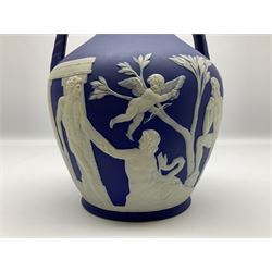 19th century Wedgwood dark blue dipped Jasperware Portland vase, of ovoid form with twin handles to shoulders and waisted neck, and flared rim, the body decorated with a continuous scene of classical figures in relief, the base decorated with portrait in relief, H26cm