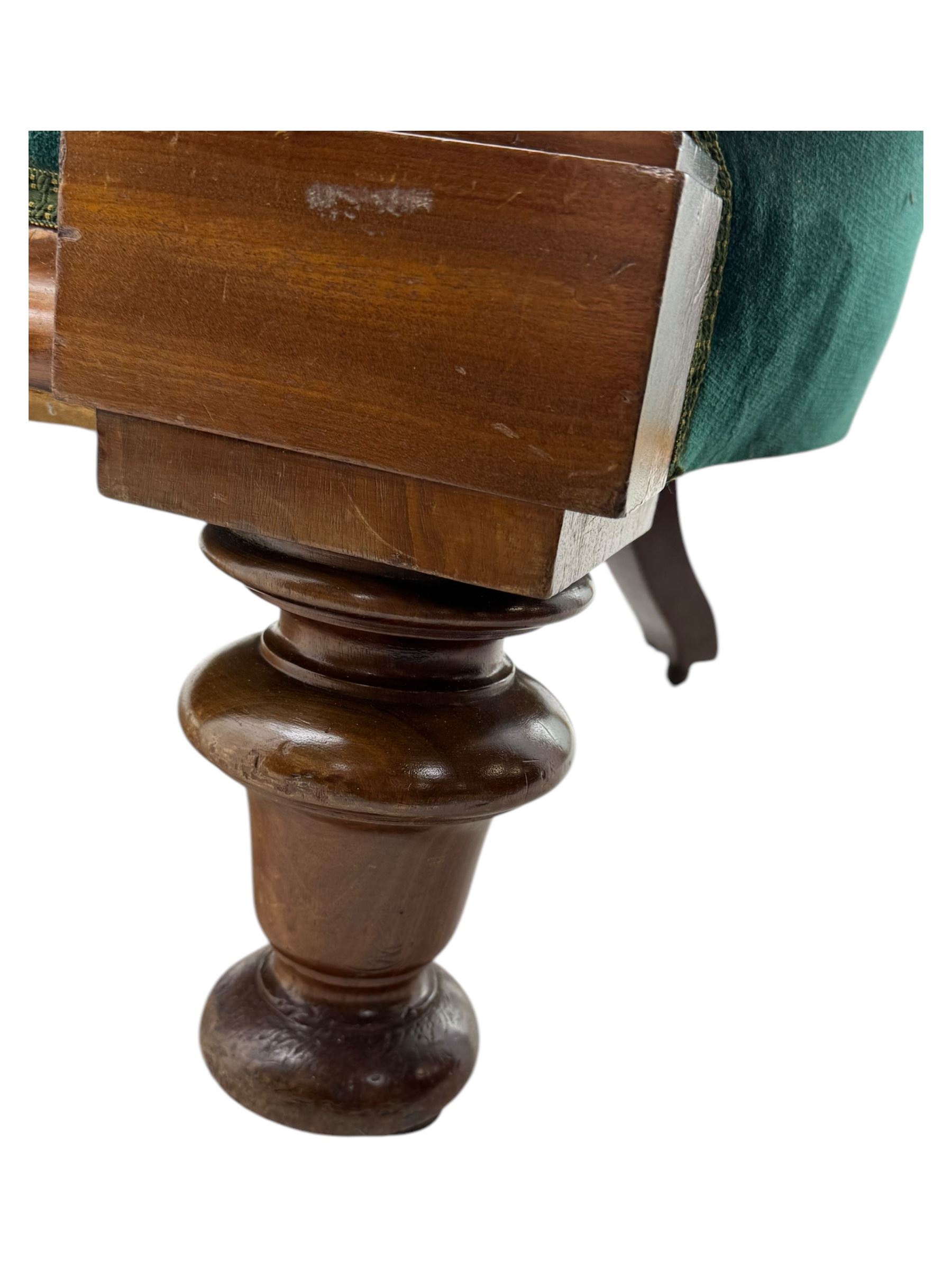 Victorian mahogany settee, upholstered in green buttoned fabric, moulded frame and scroll carved arm terminals, turned supports on castors