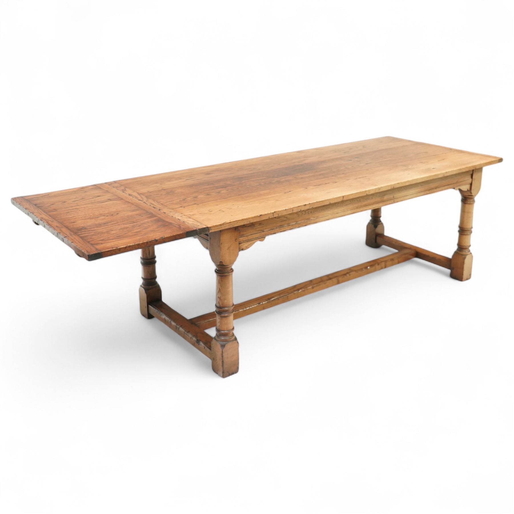 Late 20th century oak refectory table in 17th century style, with plank top and end leaf, raised on ring turned baluster legs with square feet, joined by conforming stretchers (260 cm extended)