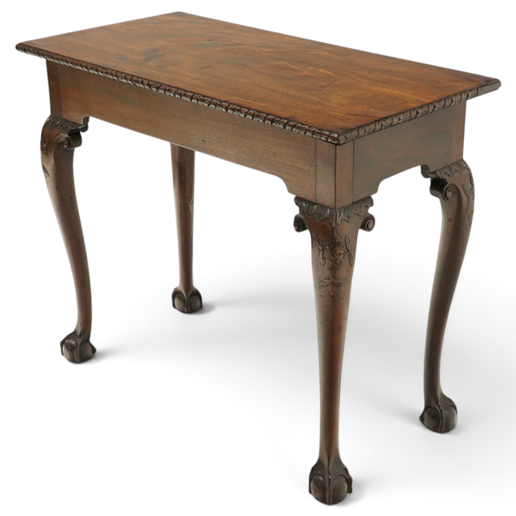 George I carved mahogany side table, adapted from a card table, the rectangular top with foliate-carved edge above a plain frieze, raised on cabriole legs with acanthus-carved knees, volute brackets and floral-carved motifs, terminating to ball-and-claw feet
