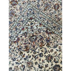 Persian Kashan ivory ground carpet, the field decorated with interlacing foliate branches and stylised plant motifs, scrolling border decorated with repeating palmettes, within floral pattern guard bands
