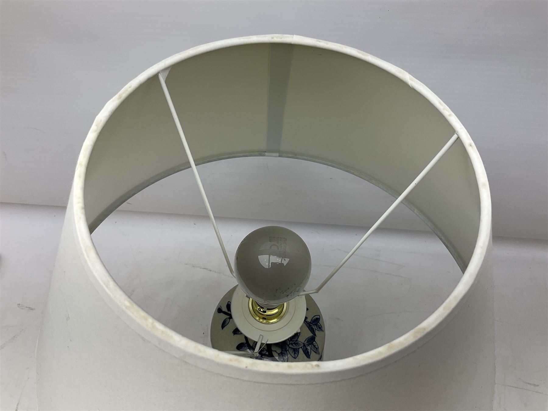 India Jane table lamp, decorated with blue birds and floral vines upon a white ground, fitted with a cream lampshade, H62cm 